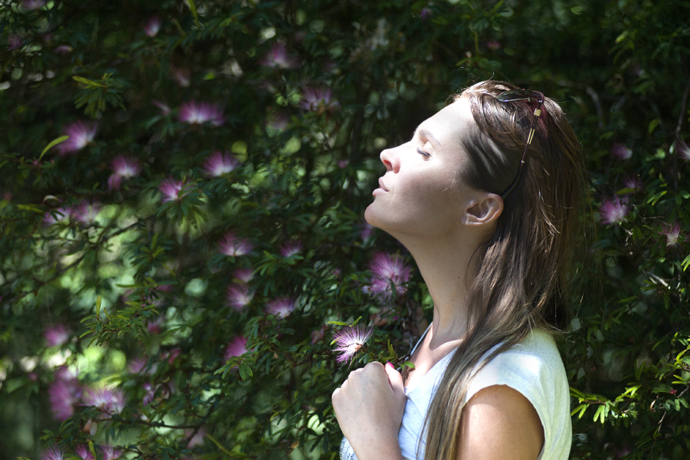 Woman smelling flowers outside