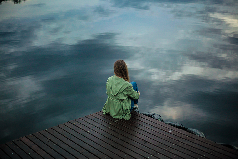 Woman sitting alone on a jetty